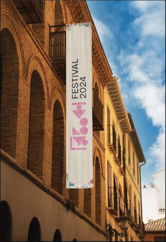 Festival banner hanging from a brick building
